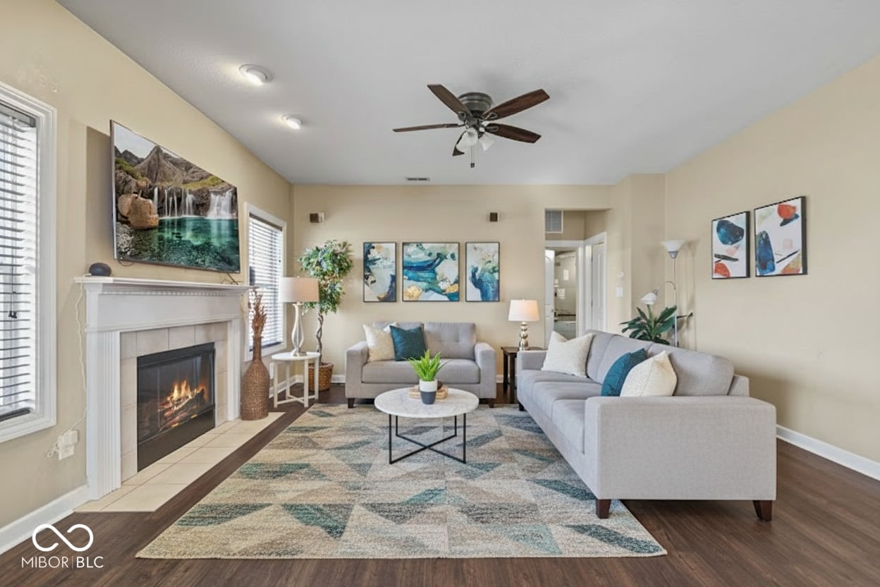 Bright living room with fireplace and hardwood floors.