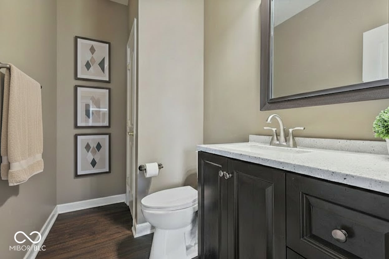 Sleek primary bath with dark vanity and quartz counters.