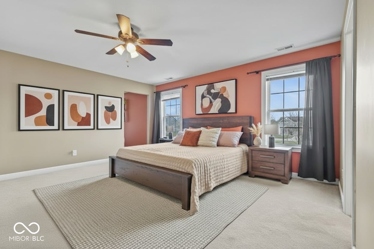 Bright primary bedroom with warm accent wall and abundant natural light.