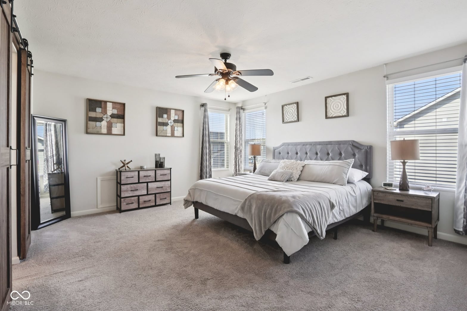 Spacious primary bedroom with balcony and abundant natural light.