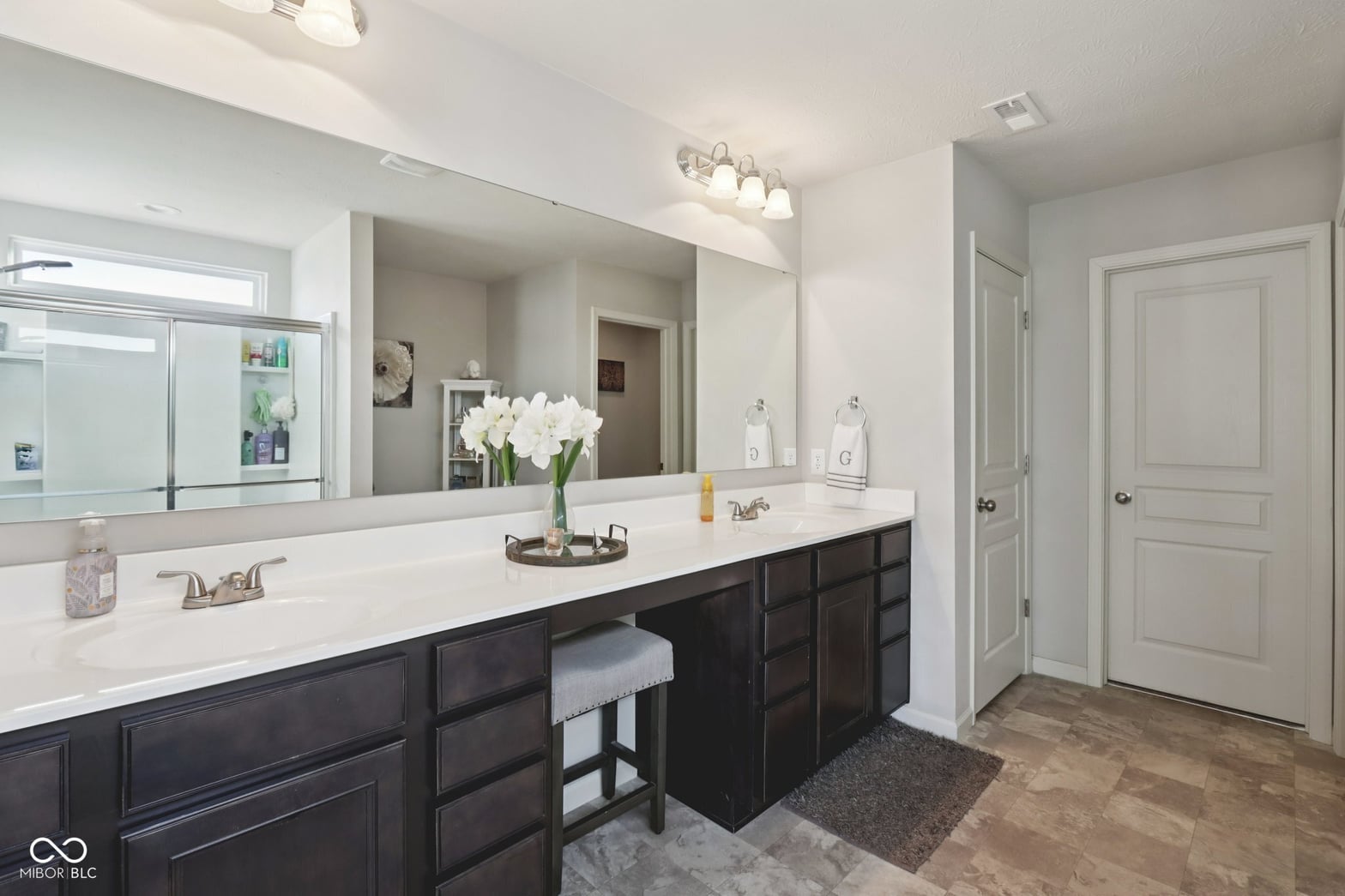 Spacious primary bath with luxe double vanity and seating.