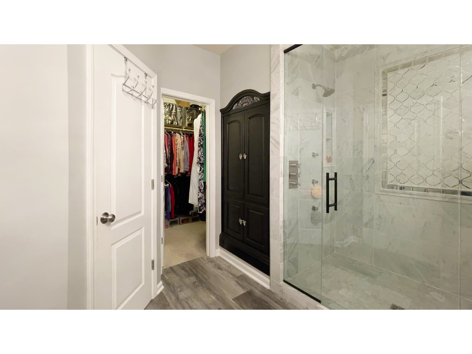 Luxurious primary bath with marble shower and walk-in closet.