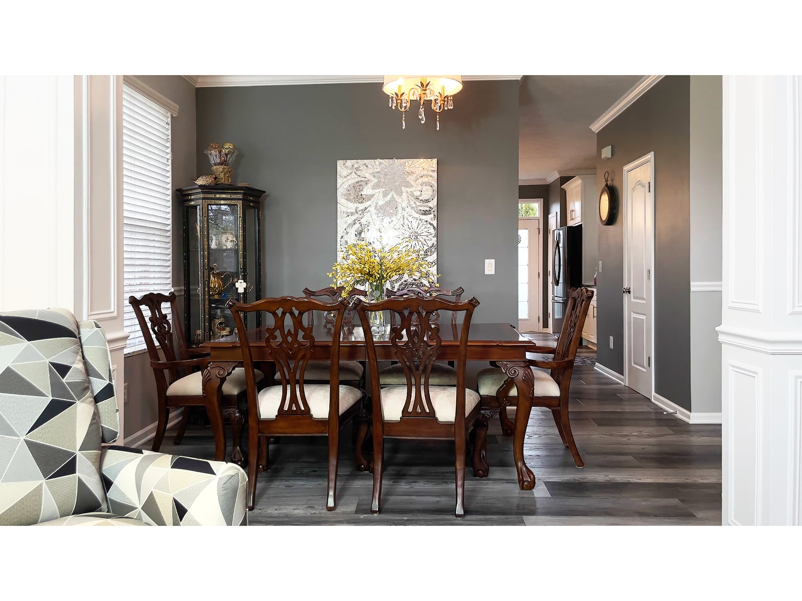 Elegant dining room with hardwood floors and chandelier.
