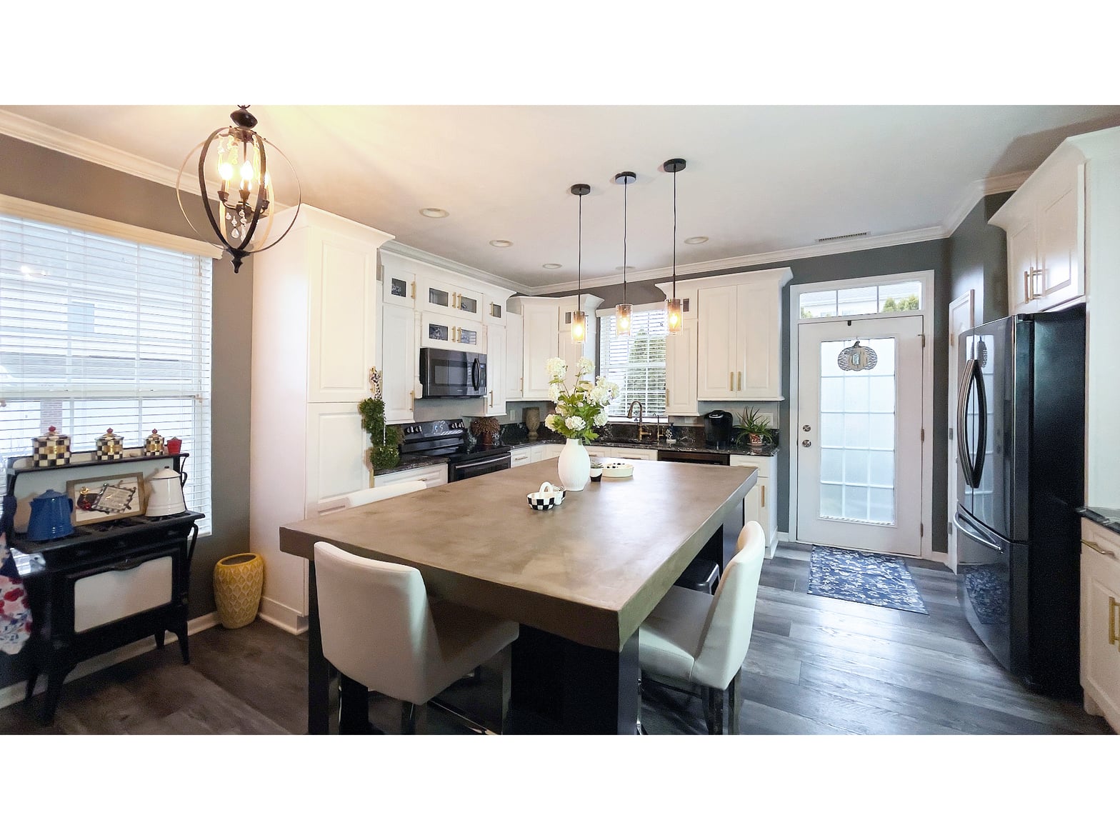 Stunning renovated kitchen with white cabinetry and island seating.