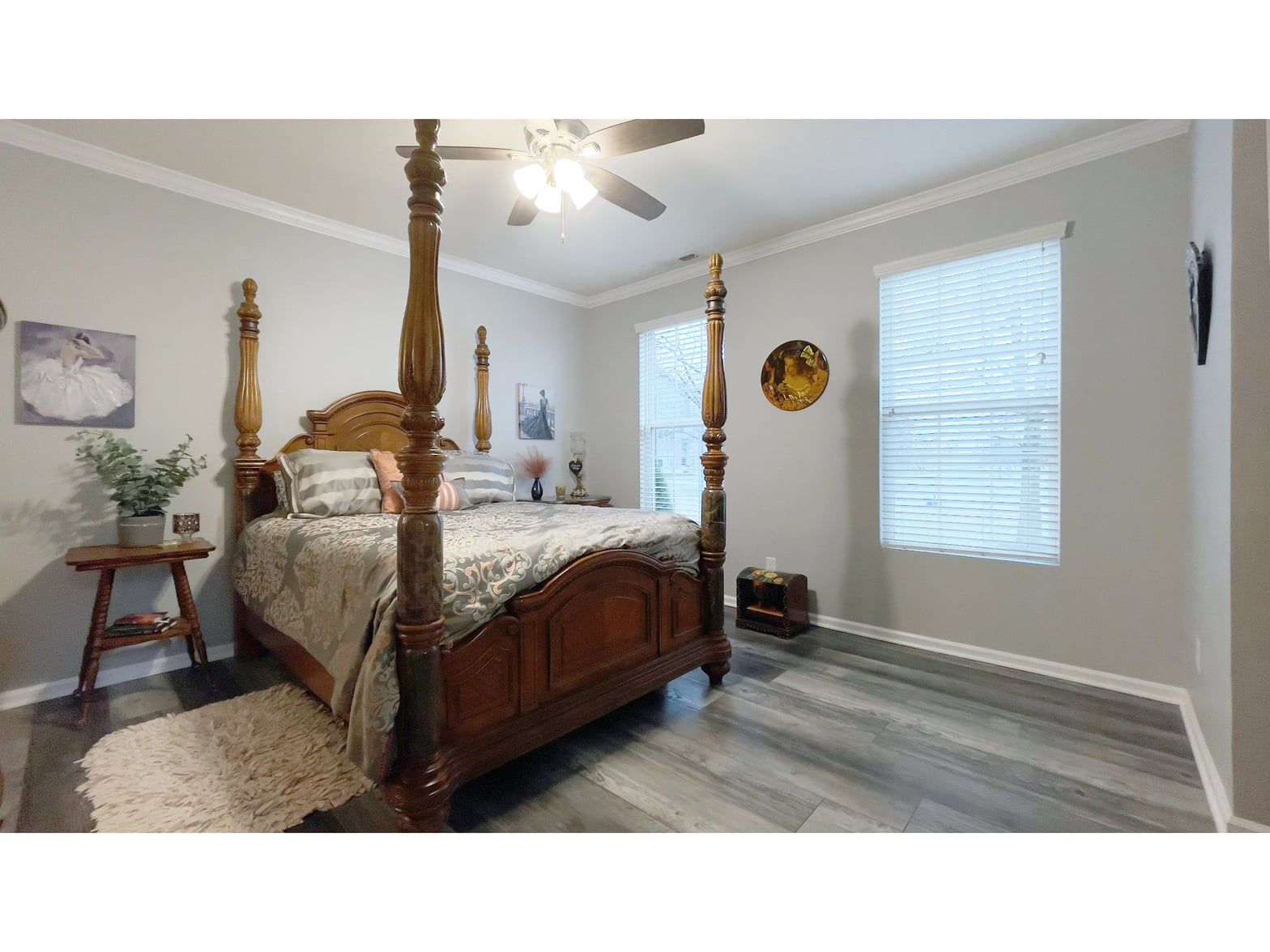 Elegant primary bedroom with four-poster bed and hardwood floors.