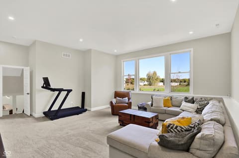 Family room at 1560 Old Hickory Lane, Westfield, IN — Bright family room with expansive windows and fitness area.