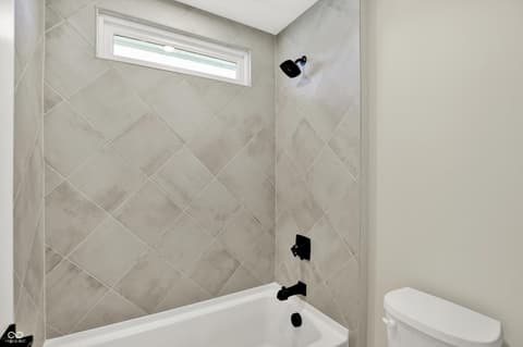 Primary bathroom at 1560 Old Hickory Lane, Westfield, IN — Elegant updated bath with designer tile surround.