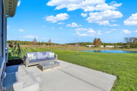 Outdoor living area at 1560 Old Hickory Lane, Westfield, IN — Spacious patio with stunning pond and open acreage views.