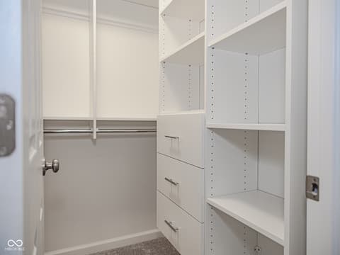 Primary bedroom at 12517 Timber Creek Drive, Carmel, IN — Spacious walk-in closet with custom built-in storage.