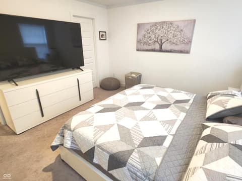 Primary bedroom at 6959 Equality Boulevard, Carmel, IN — Spacious primary bedroom with modern entertainment setup.