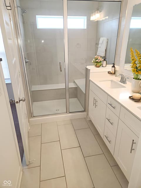 Primary bathroom at 6959 Equality Boulevard, Carmel, IN — Bright, spa-like primary bath with frameless shower.