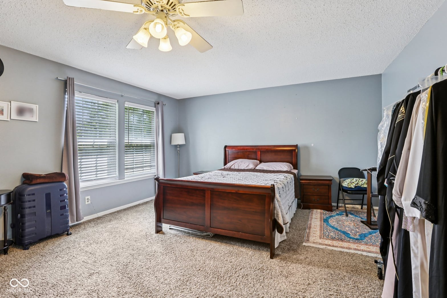 Spacious primary bedroom with abundant natural light and shutters.
