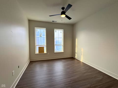 Bedroom at 925 Veterans Way, Carmel, IN — Bright bedroom with hardwood floors and dual windows.