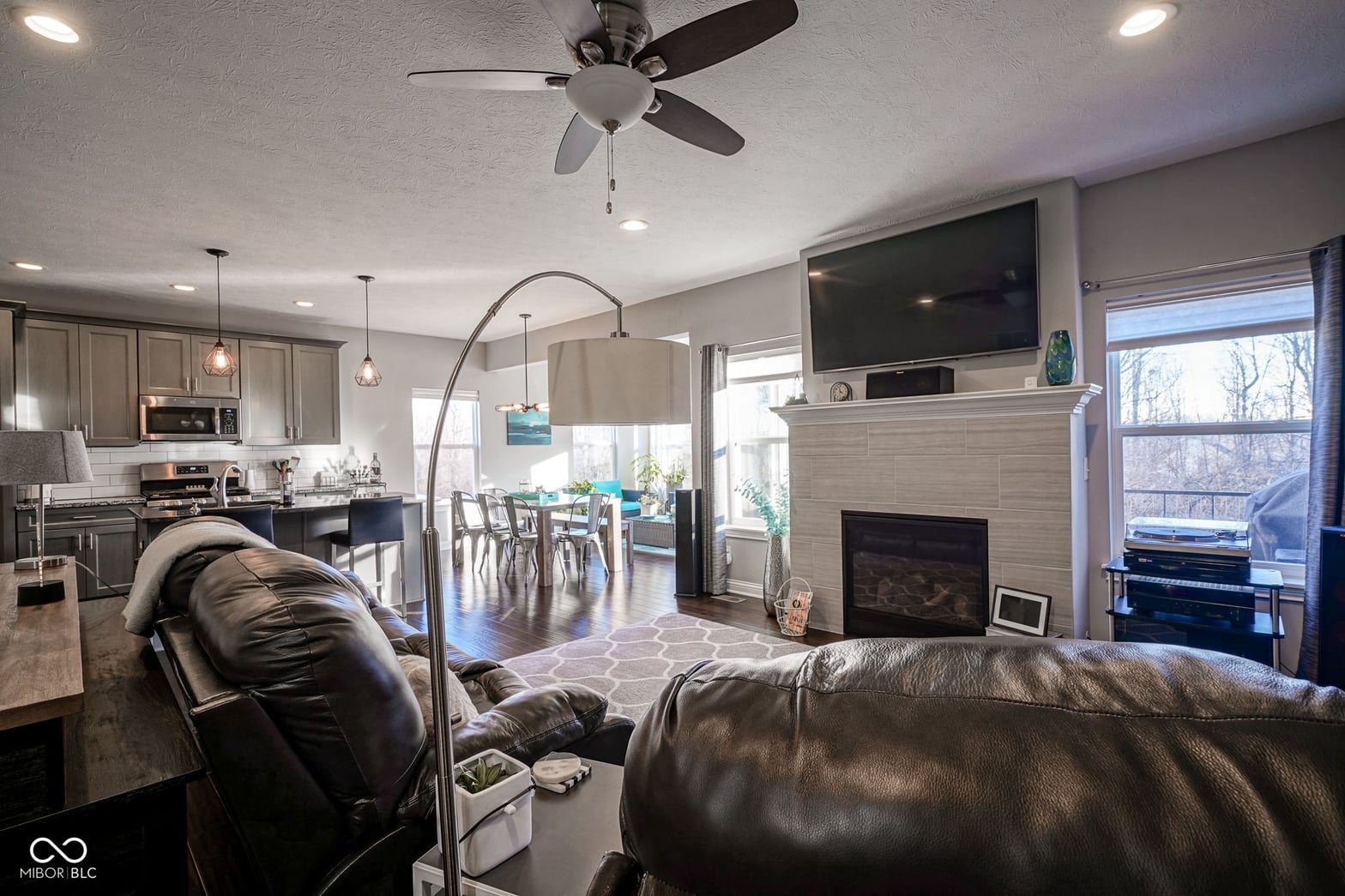 Open-concept living with fireplace and modern kitchen.