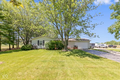 Front exterior at 8440 E 216th Street, Cicero, IN — Charming home on well-landscaped lot with mature trees