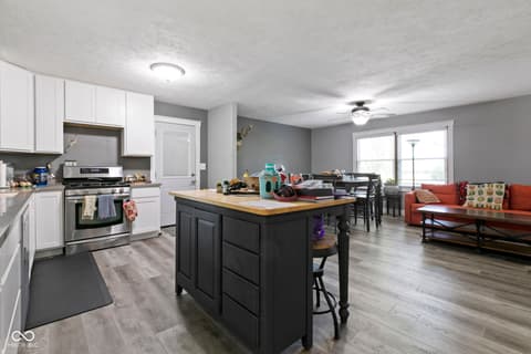 Kitchen at 8440 E 216th Street, Cicero, IN — Open-concept kitchen with black island and hardwood floors.