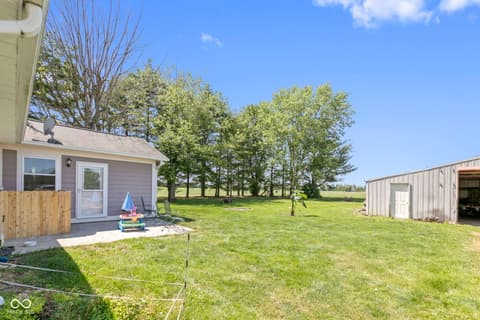 Backyard at 8440 E 216th Street, Cicero, IN — Large level backyard with mature trees and storage shed.