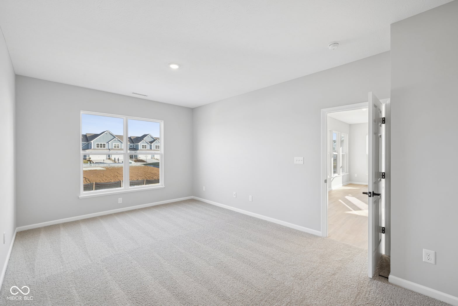 Bright primary bedroom with expansive windows and ensuite access.