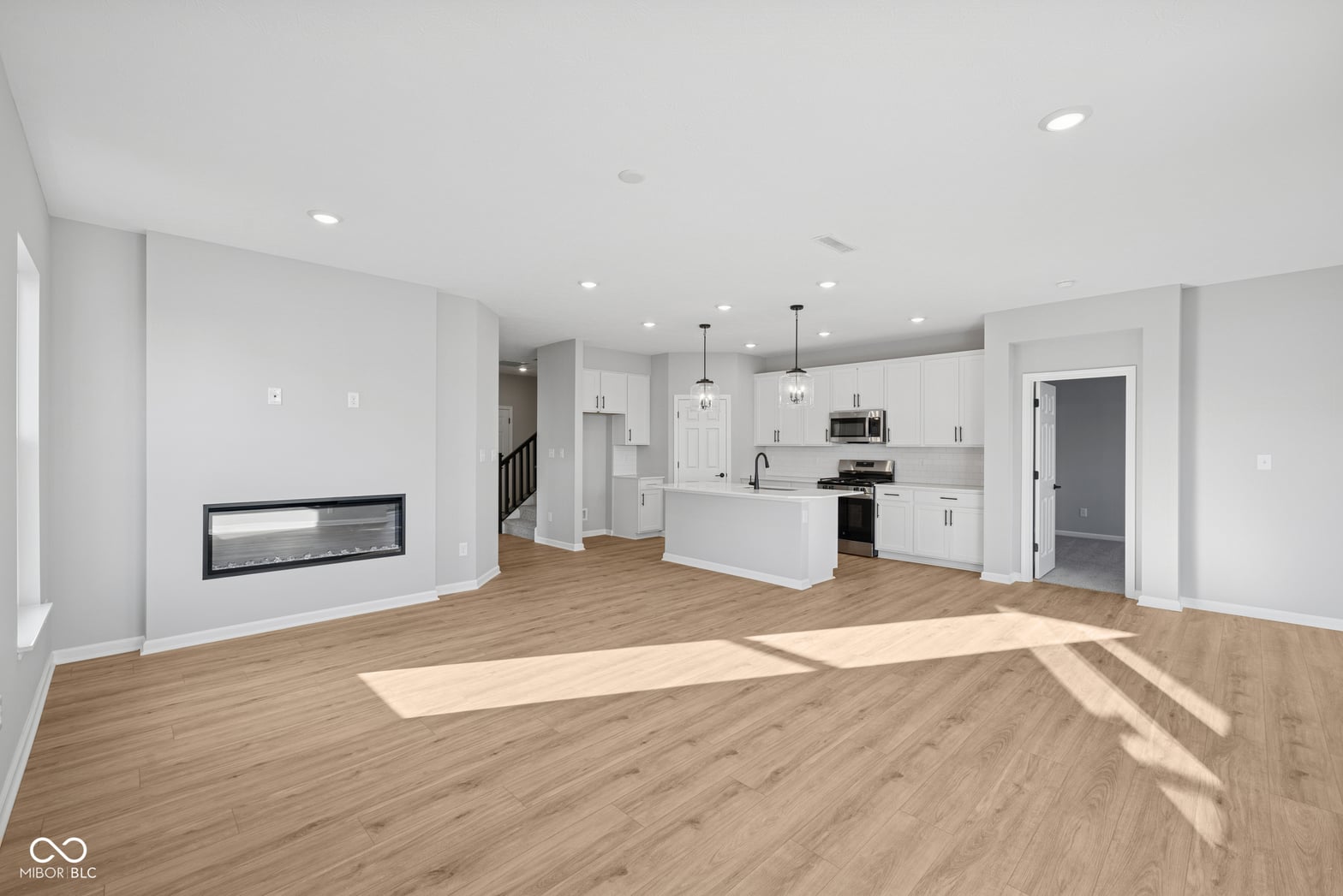 Bright contemporary open plan with modern kitchen and fireplace.