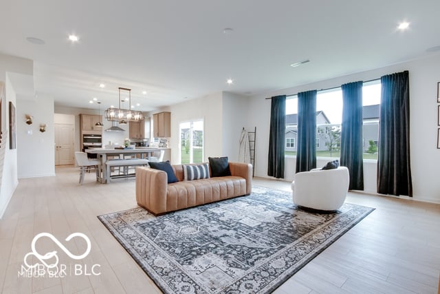 Bright modern living space with open kitchen and large windows.