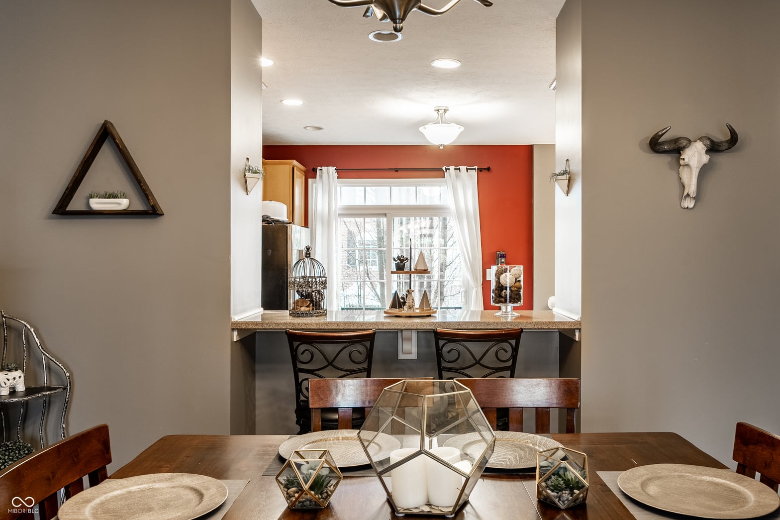 Modern dining with dual vanity bar and vibrant accent wall.