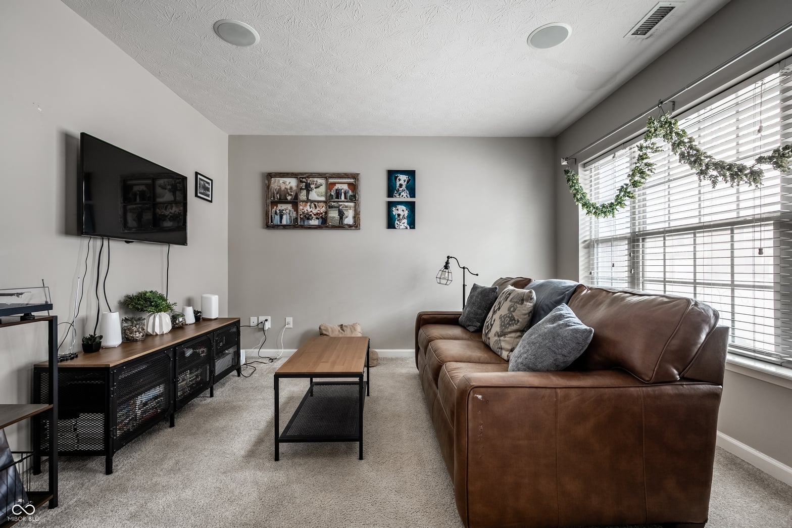 Bright family room with leather seating and large windows.