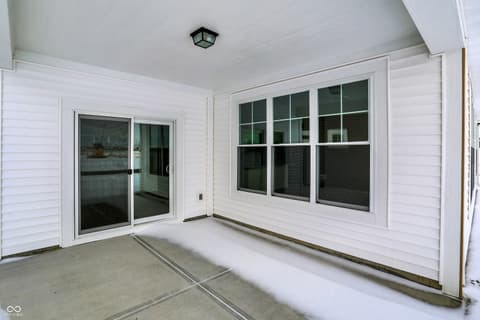 Outdoor living area at 19785 Highclere Lane, Sheridan, IN — Bright covered patio with multiple glass doors and windows.