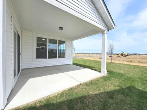 Outdoor living area at 19785 Highclere Lane, Sheridan, IN — Spacious covered patio with scenic open land views.