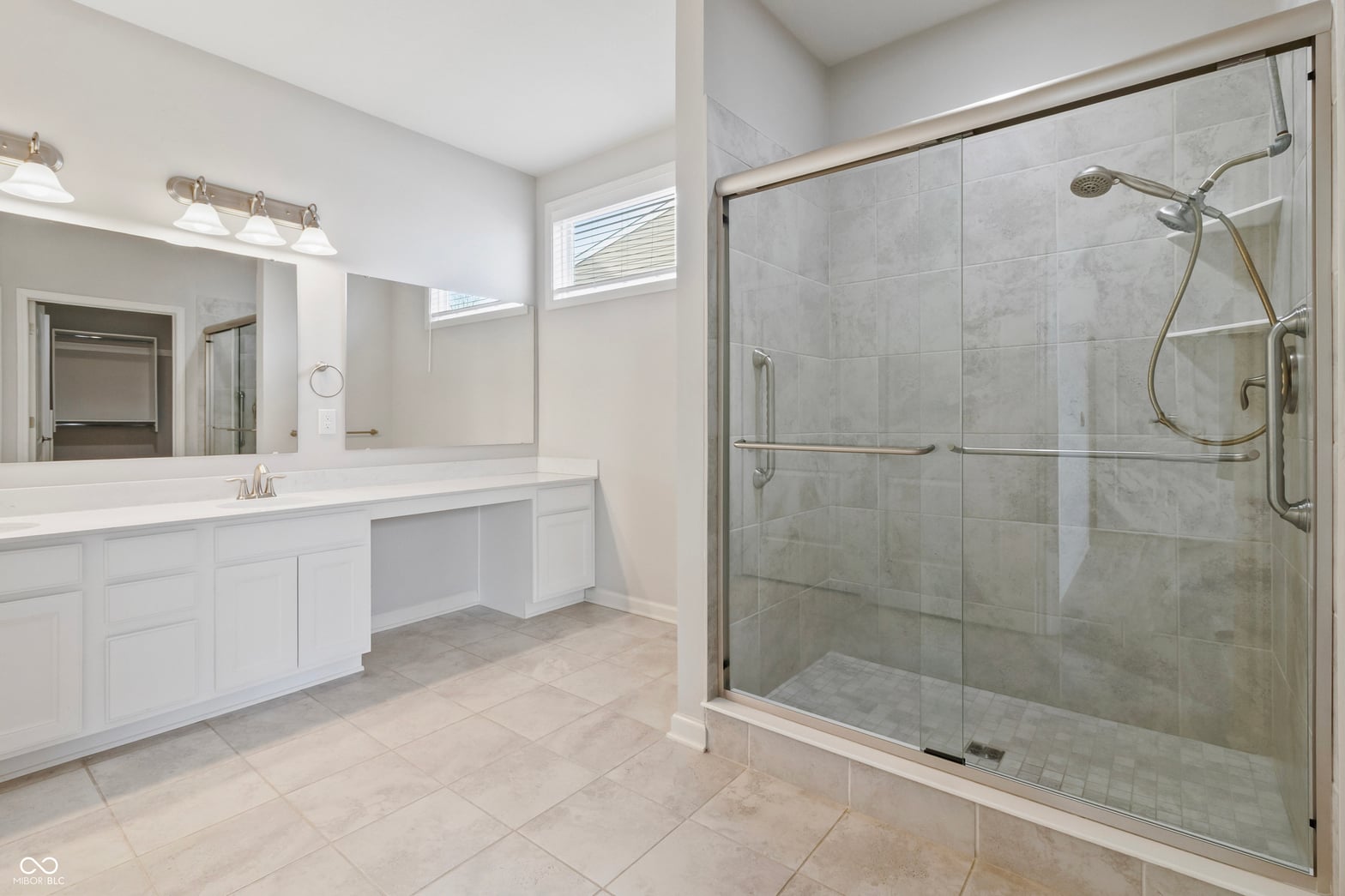 Luxurious primary bath with frameless shower and dual vanity.
