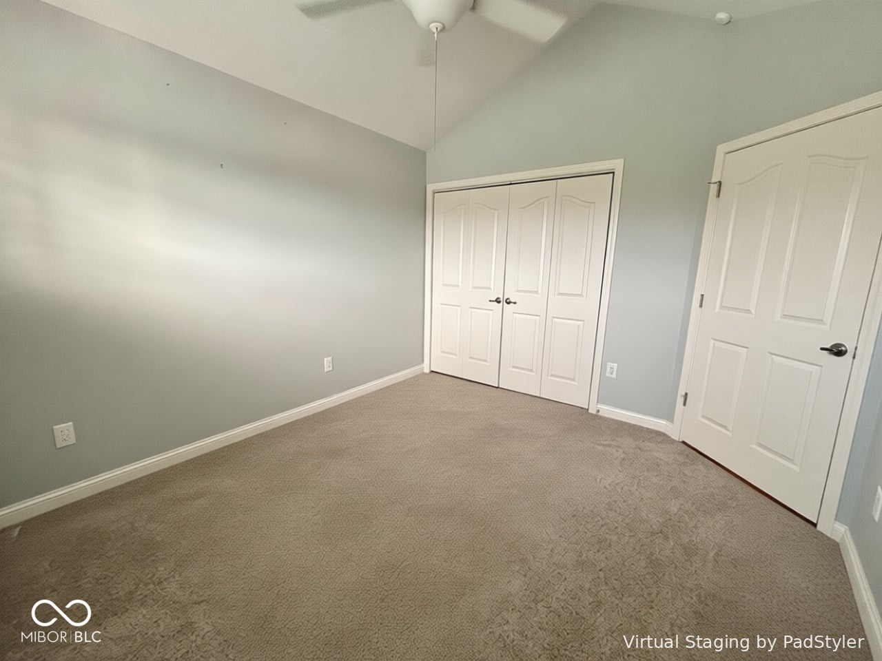 Spacious primary bedroom with vaulted ceiling and dual closets.