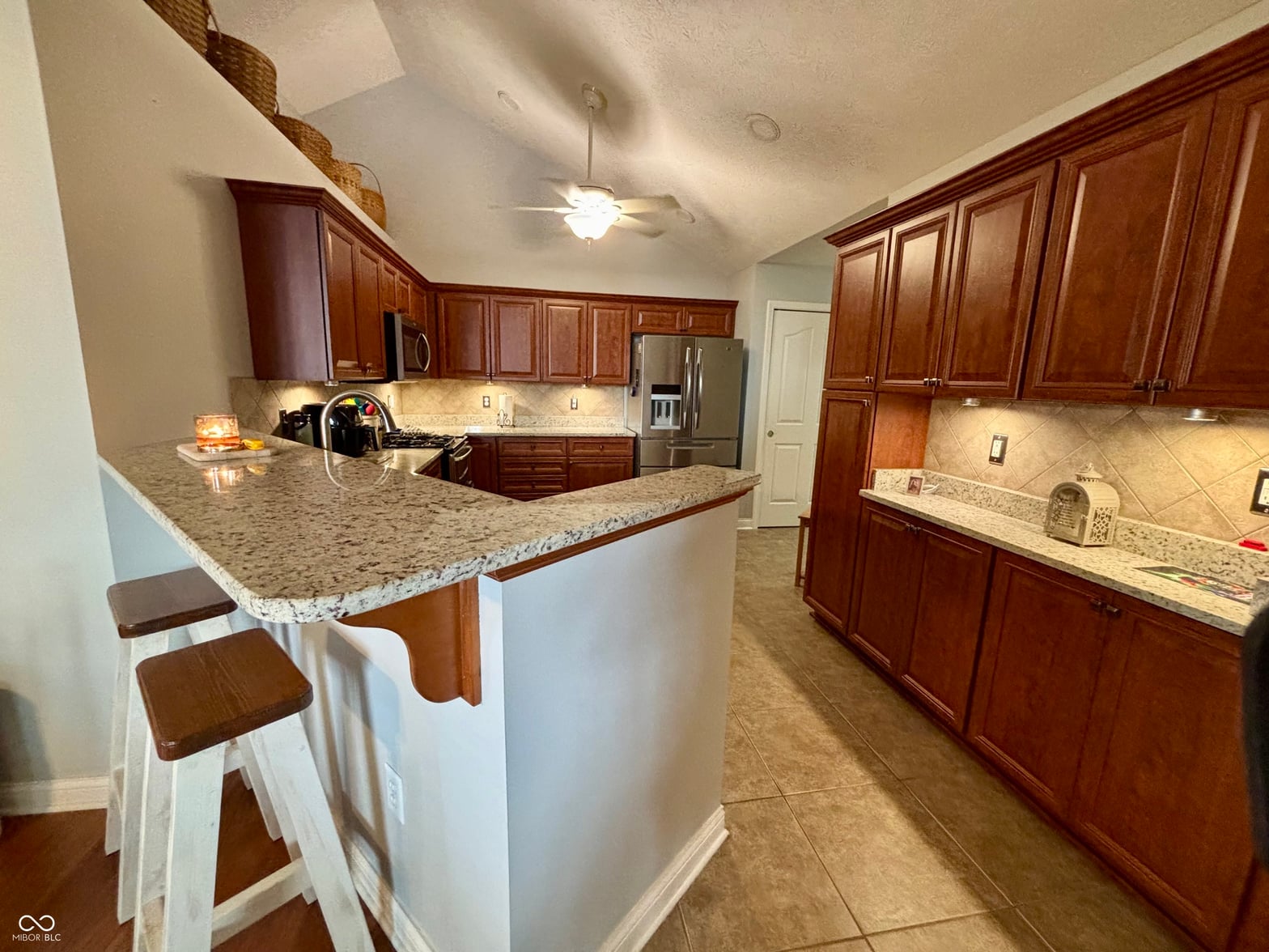 Spacious kitchen with granite counters and dark wood cabinets.