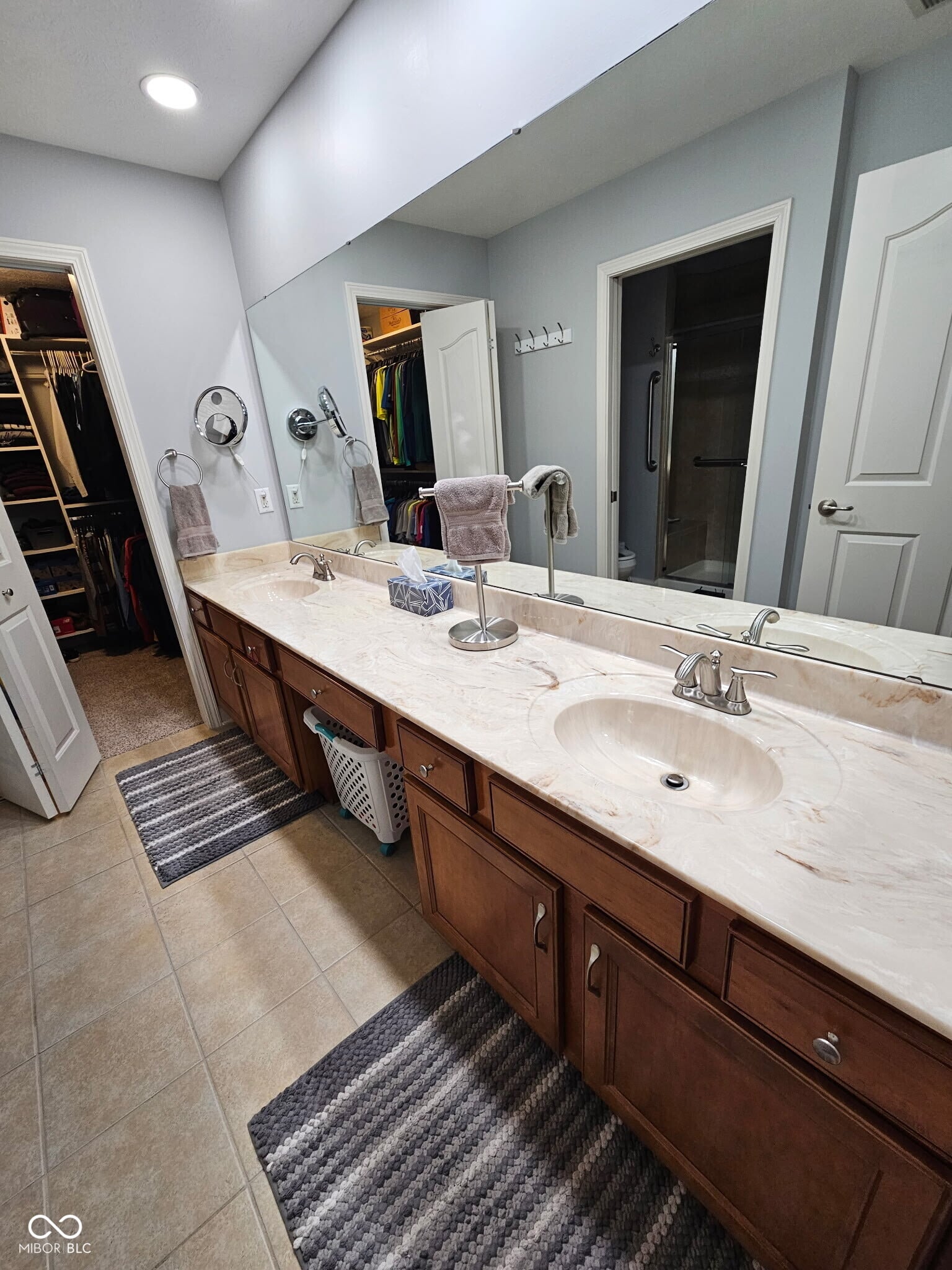 Spacious primary bath with dual marble vanity and walk-in closet