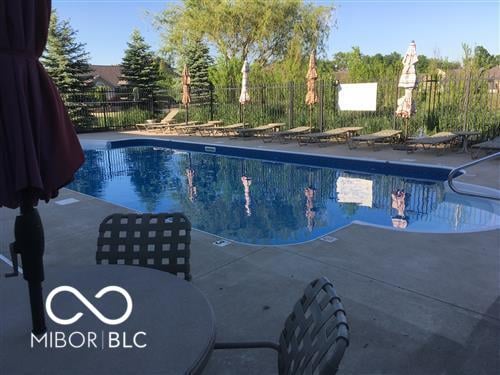 Resort-style pool with mature trees and spacious concrete deck.
