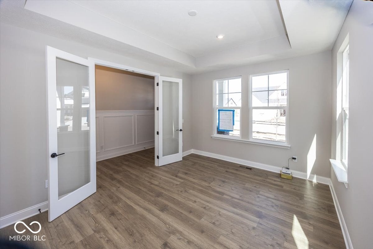 Bright primary bedroom with hardwood floors and ensuite access.