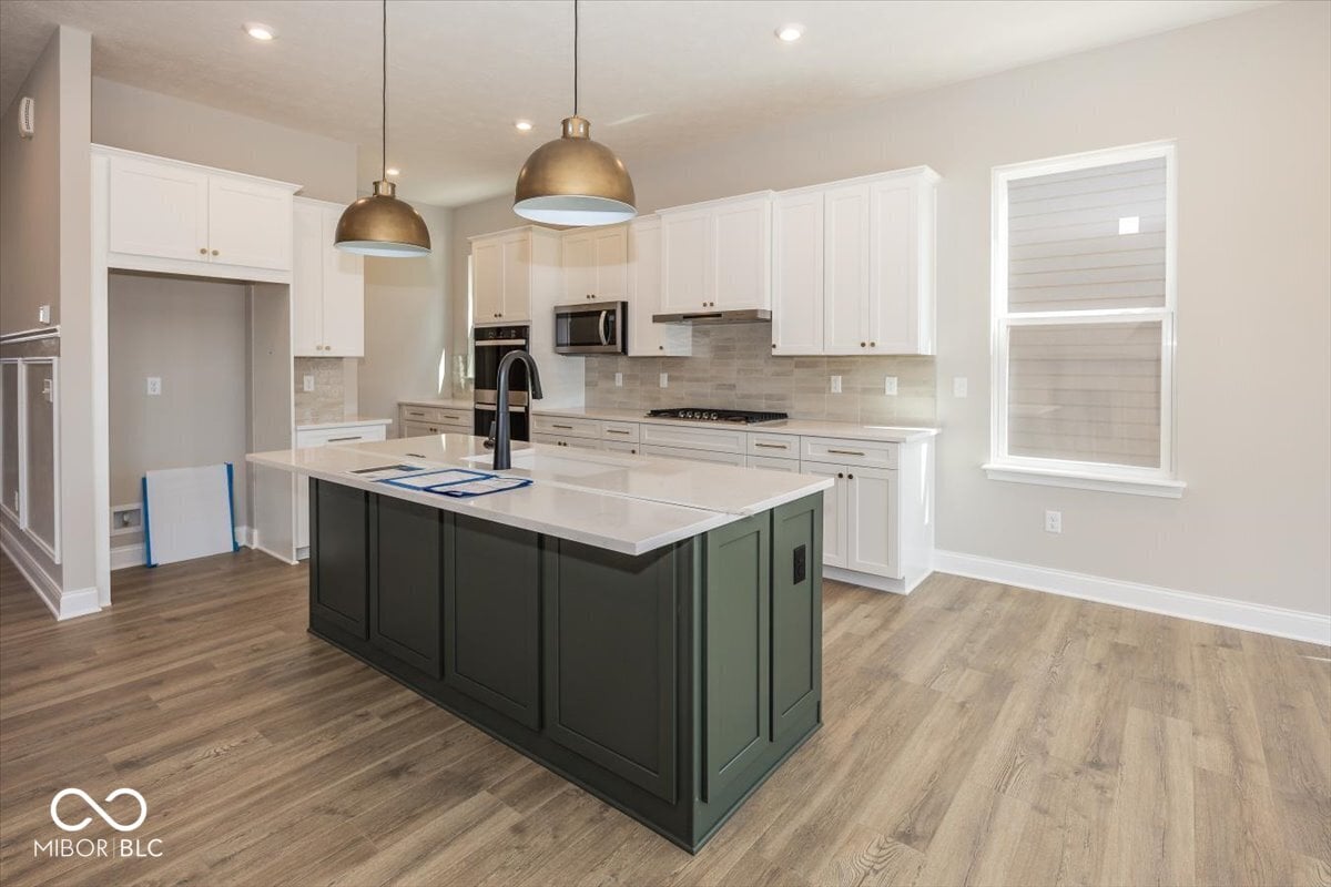 Modern kitchen with white cabinetry and quartz island.