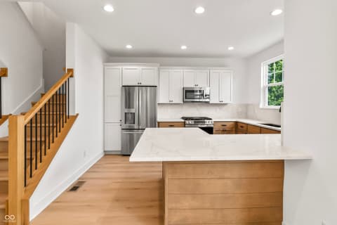 Kitchen at 15407 Mystic Rock Drive, Carmel, IN — Stunning renovated kitchen with marble counters and island.