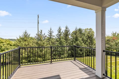 Outdoor living area at 15407 Mystic Rock Drive, Carmel, IN — Stunning elevated deck with panoramic tree-line views.