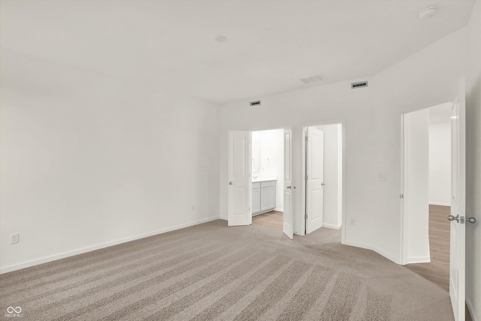 Spacious primary bedroom with multiple walk-in closets.