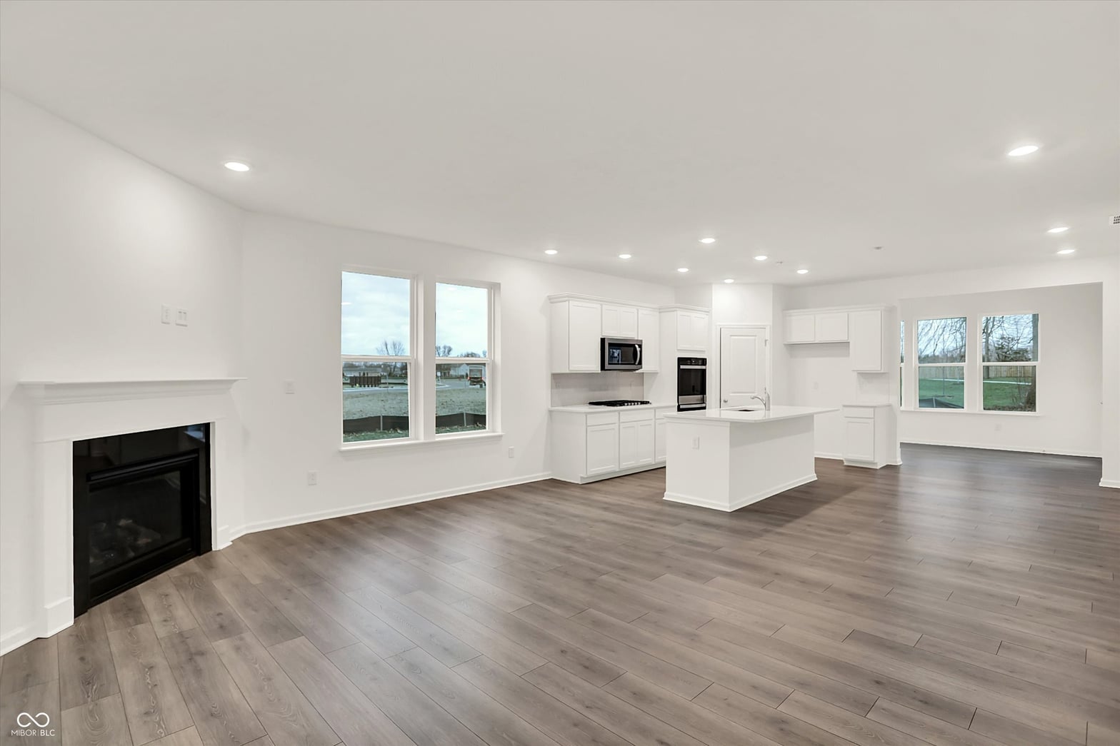 Bright open-concept living with modern kitchen and fireplace.