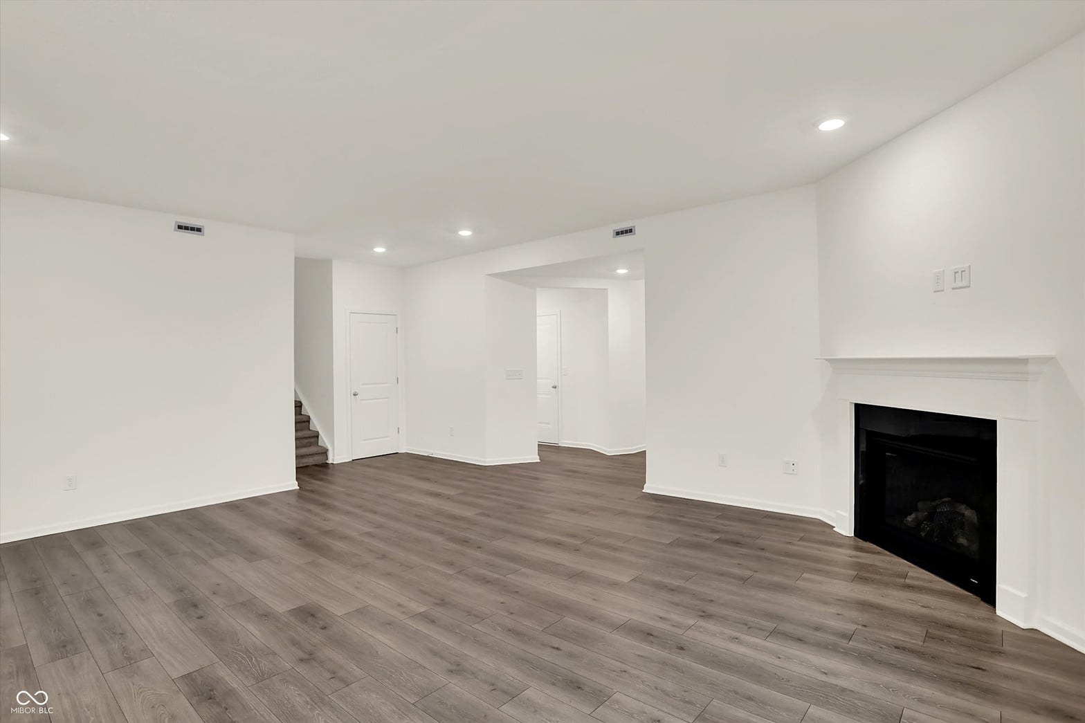 Spacious modern family room with fireplace and hardwoods.