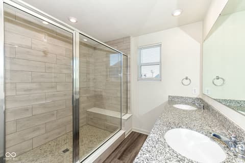 Primary bathroom at 13533 Dewpoint Lane, Fishers, IN — Luxurious spa-inspired primary bath with frameless shower.