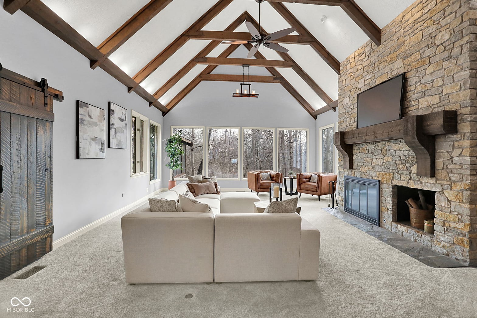 Stunning vaulted ceiling with exposed beams and stone fireplace.