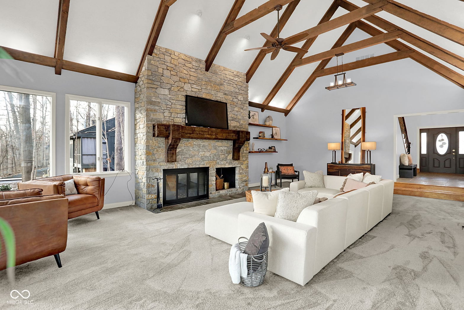 Stunning vaulted living room with exposed beams and stone fireplace.