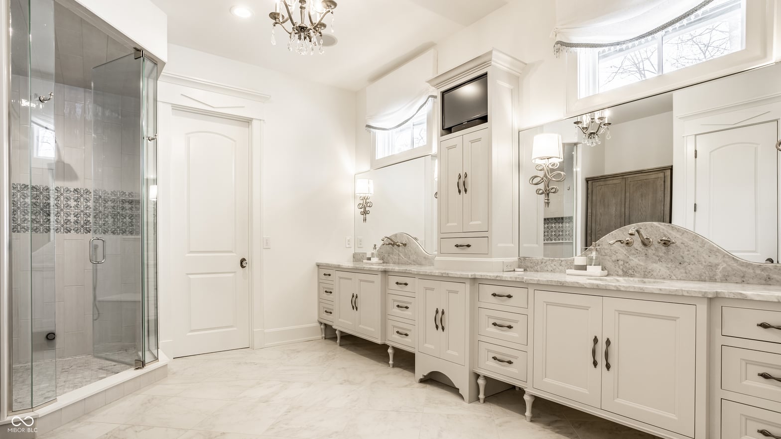 Luxurious primary bath with dual marble vanities and spa shower.