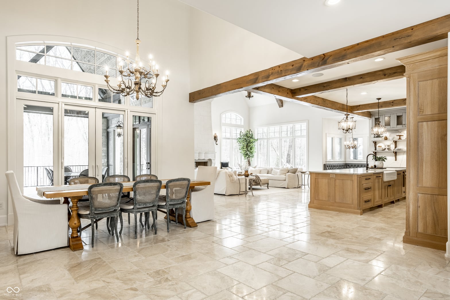 Bright open kitchen with exposed beams and marble floors.