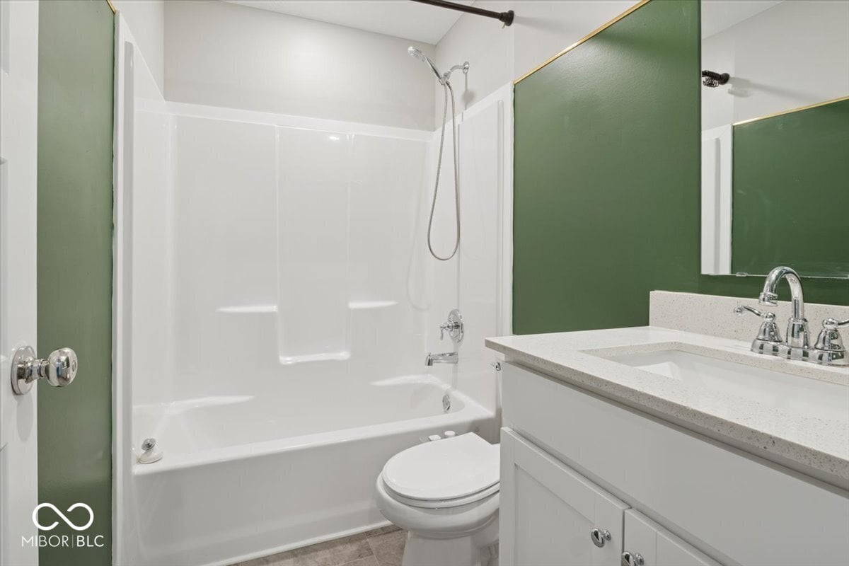 Modern primary bath with walk-in shower and quartz vanity.