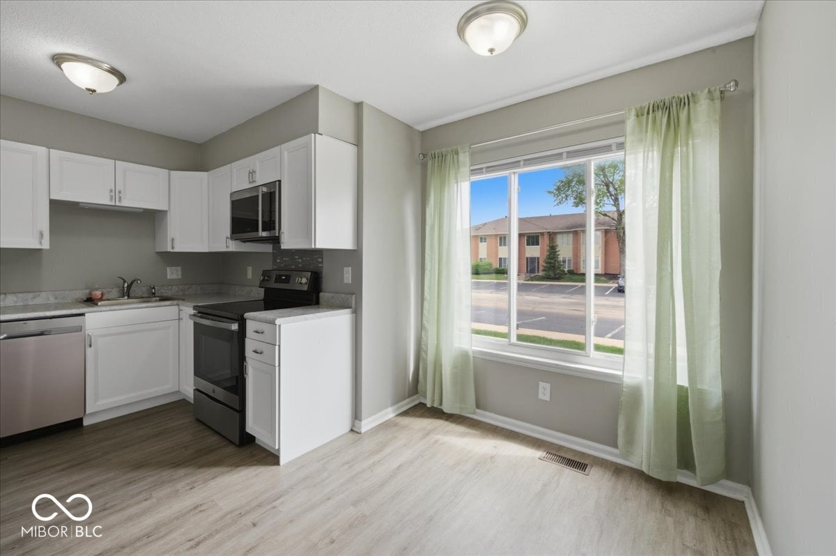 Bright kitchen with white cabinets and modern appliances.