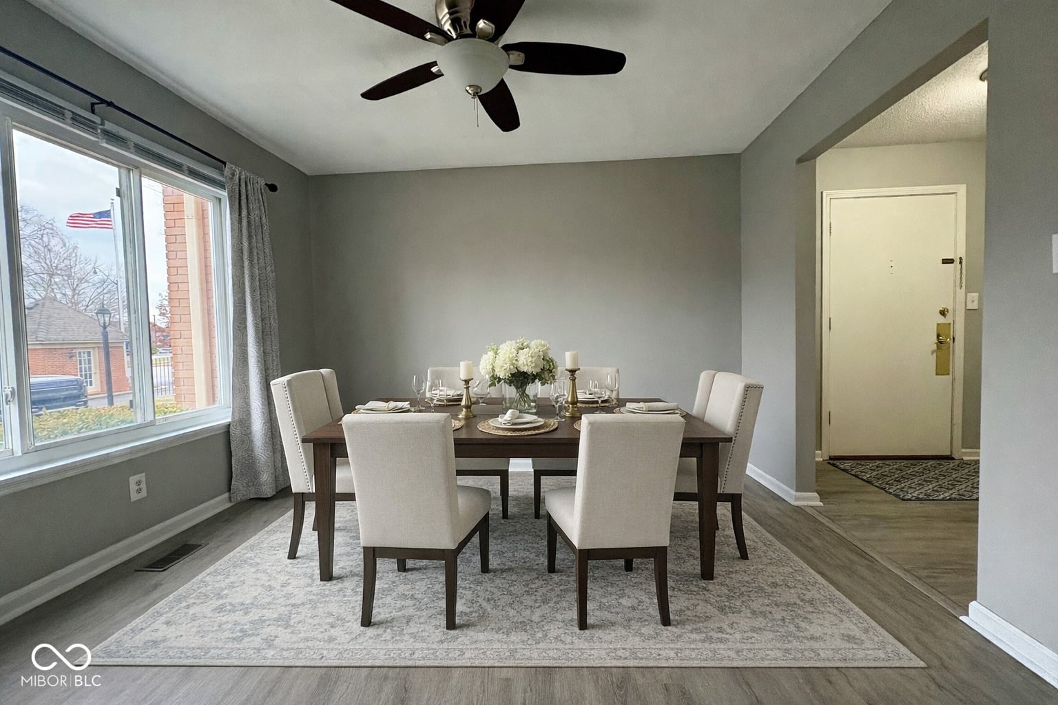 Bright dining room with large windows and hardwood floors.