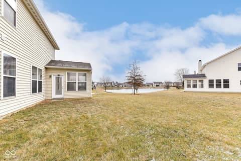 Backyard at 11035 Cool Winds Way, Fishers, IN — Expansive backyard with sunroom and water views.