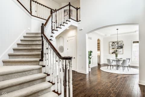 Foyer at 13429 Boxelder Court, Carmel, IN — Elegant two-story foyer with grand curved staircase.